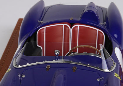 Primo piano dall'alto di un'auto da corsa classica blu con sedili in pelle rossa e volante in legno, disponibile su Vroomi.