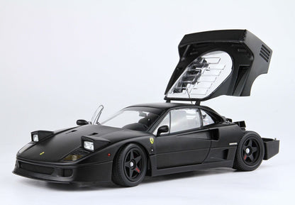 Matte black Ferrari F40 model car with open rear engine hood and front door, shown on white background, available via Vroomi