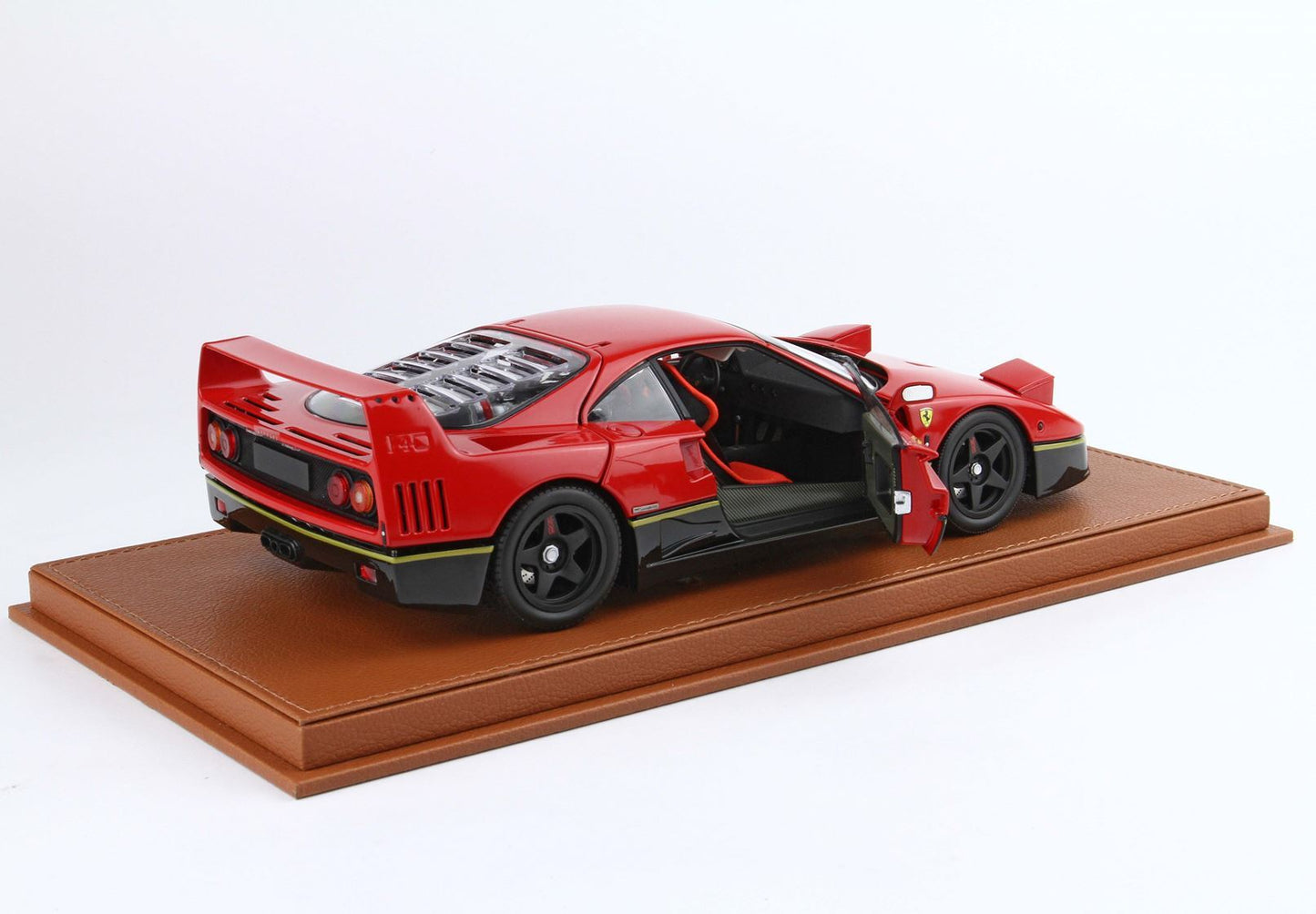 Red Ferrari F40 model car with open door on brown leather display base available on Vroomi