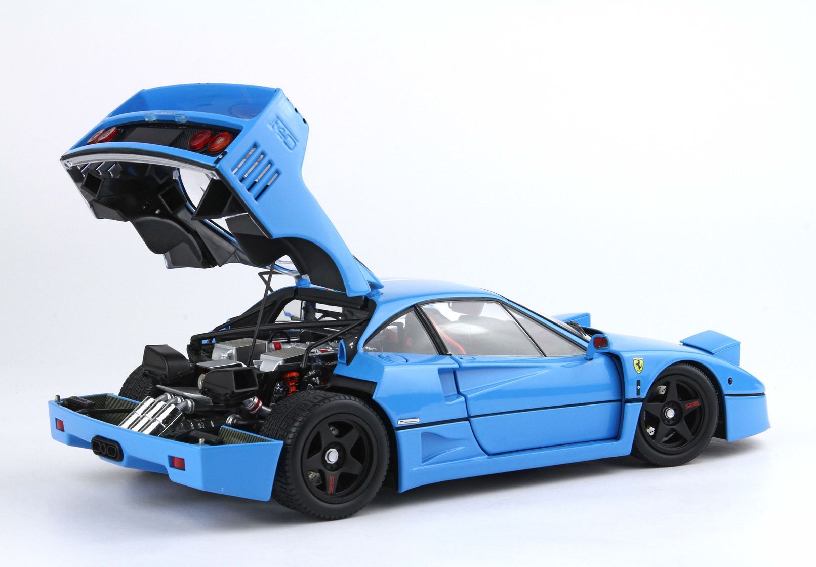 Blue Ferrari F40 model car with rear engine open, showing detailed engine and black wheels, available on the Vroomi platform