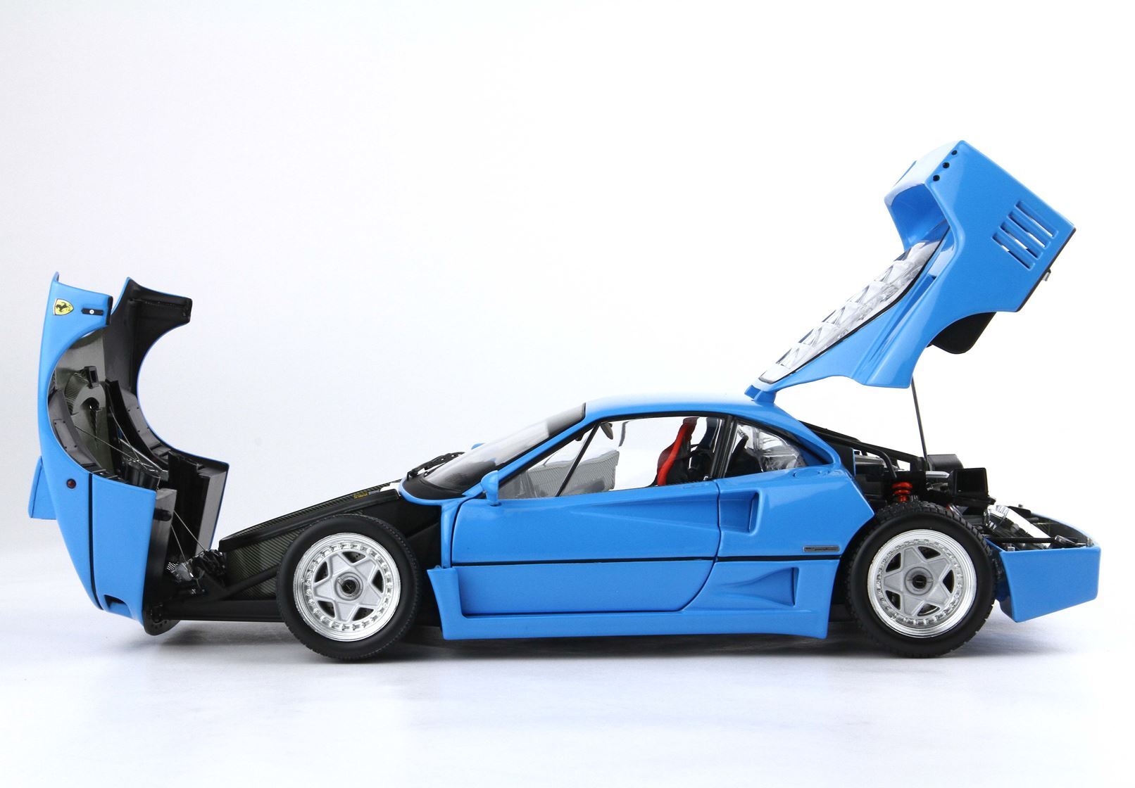 Auto sportiva blu con cofano anteriore e posteriore aperti, modello dettagliato disponibile tramite Vroomi.