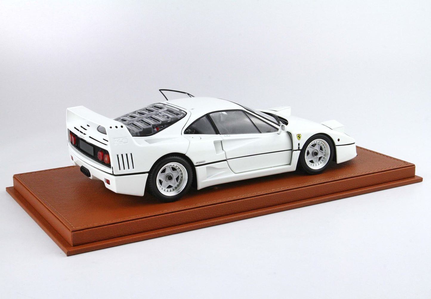 White Ferrari F40 model car on brown display base, available on Vroomi platform